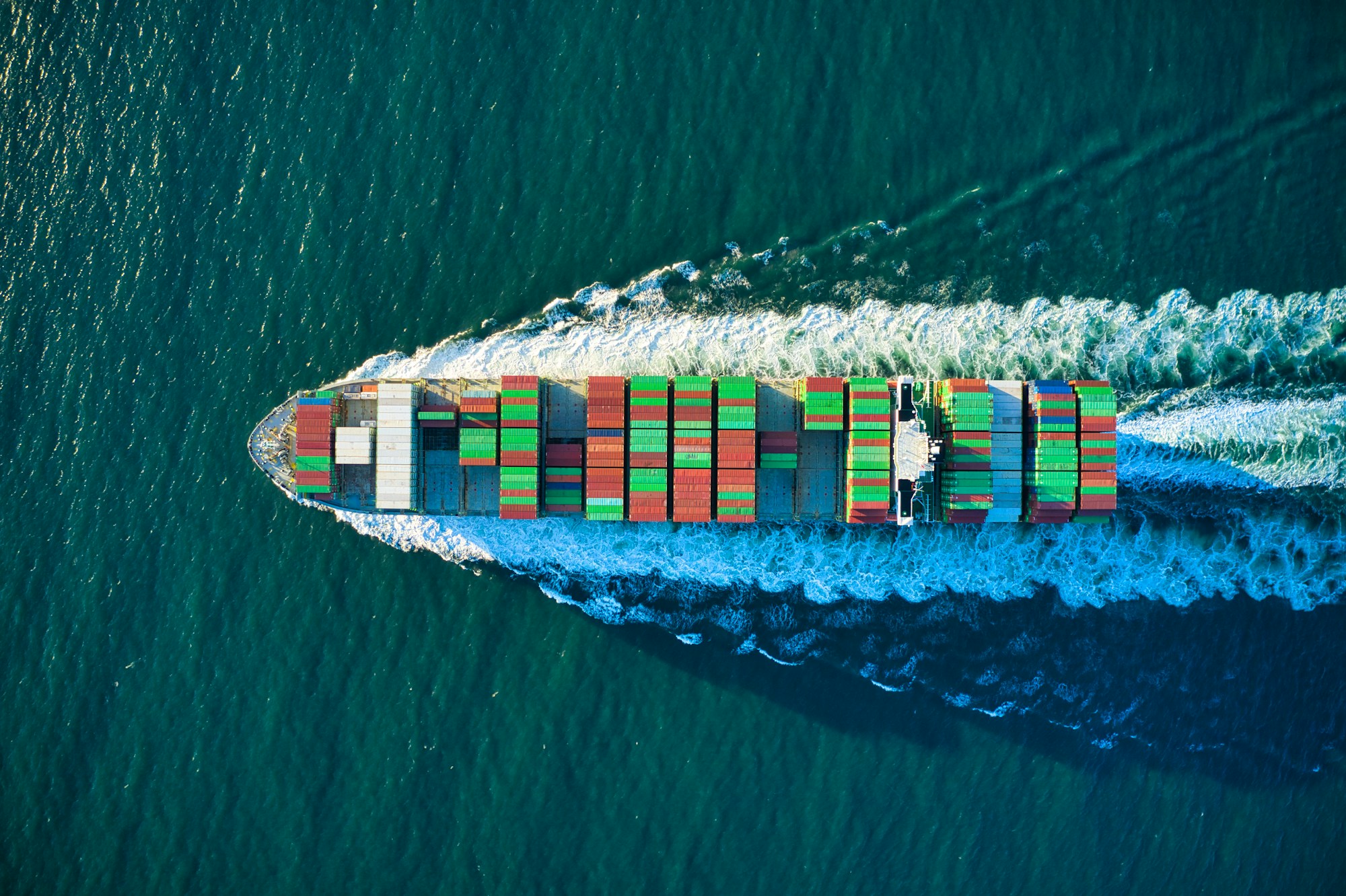 Navio cargueiro transportando contêineres em águas azuis